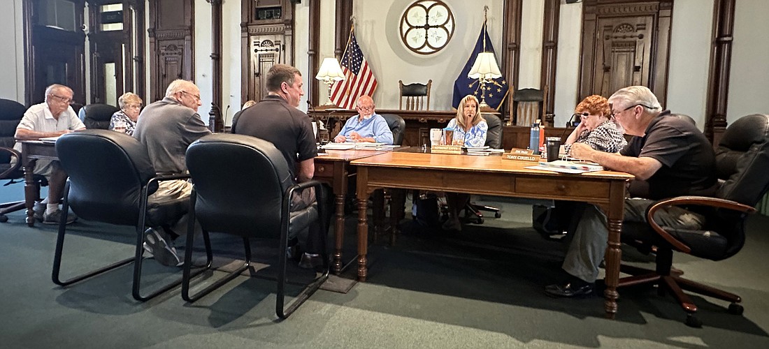 Kosciusko County Coroner Tyler Huffer (front, right) and deputy coroner Larry Ladd (front, left) listen to comments Thursday from Kosciusko County Councilman Tony Ciriello (far right), the previous county coroner, about a second vehicle for the coroner’s office. Photo by David Slone, Times-Union