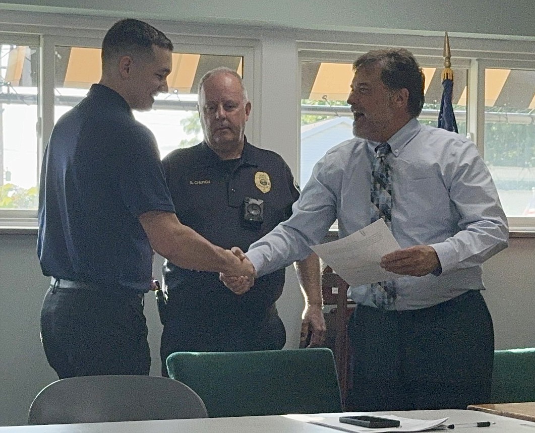 Chase Wroblewski (L) shakes hands with Jack Birch, town attorney, after being sworn into the North Webster Police Department as a new officer. Greg Church, town marshal, stands behind them. Photo by Marissa Sweatland, InkFreeNews