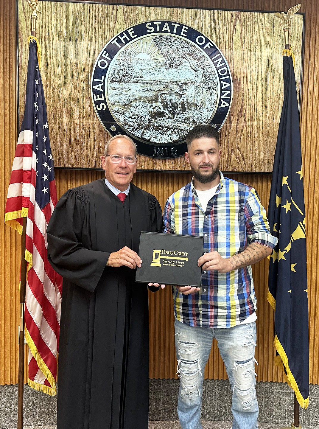 Kosciusko County Circuit Court Judge Mike Reed (L) presents Travis Belt with a certificate for completing Drug Court on Monday. Belt is the 100th graduate of Kosciusko County Drug Court since it started in 2014. Photo by David Slone, Times-Union