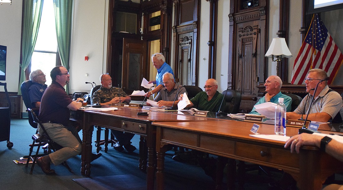 Pictured is attorney Steve Snyder handing out paperwork during the Kosciusko County Area Plan Commission meeting Wednesday. Also shown (L to R) are Matt Sandy, area plan director; Plan Commission members Larry Copeland, Mike Long, Doug Ruch, Mike Kissinger, Lee Harman and Matt Goodnight. Photo by Lauren Zeugner