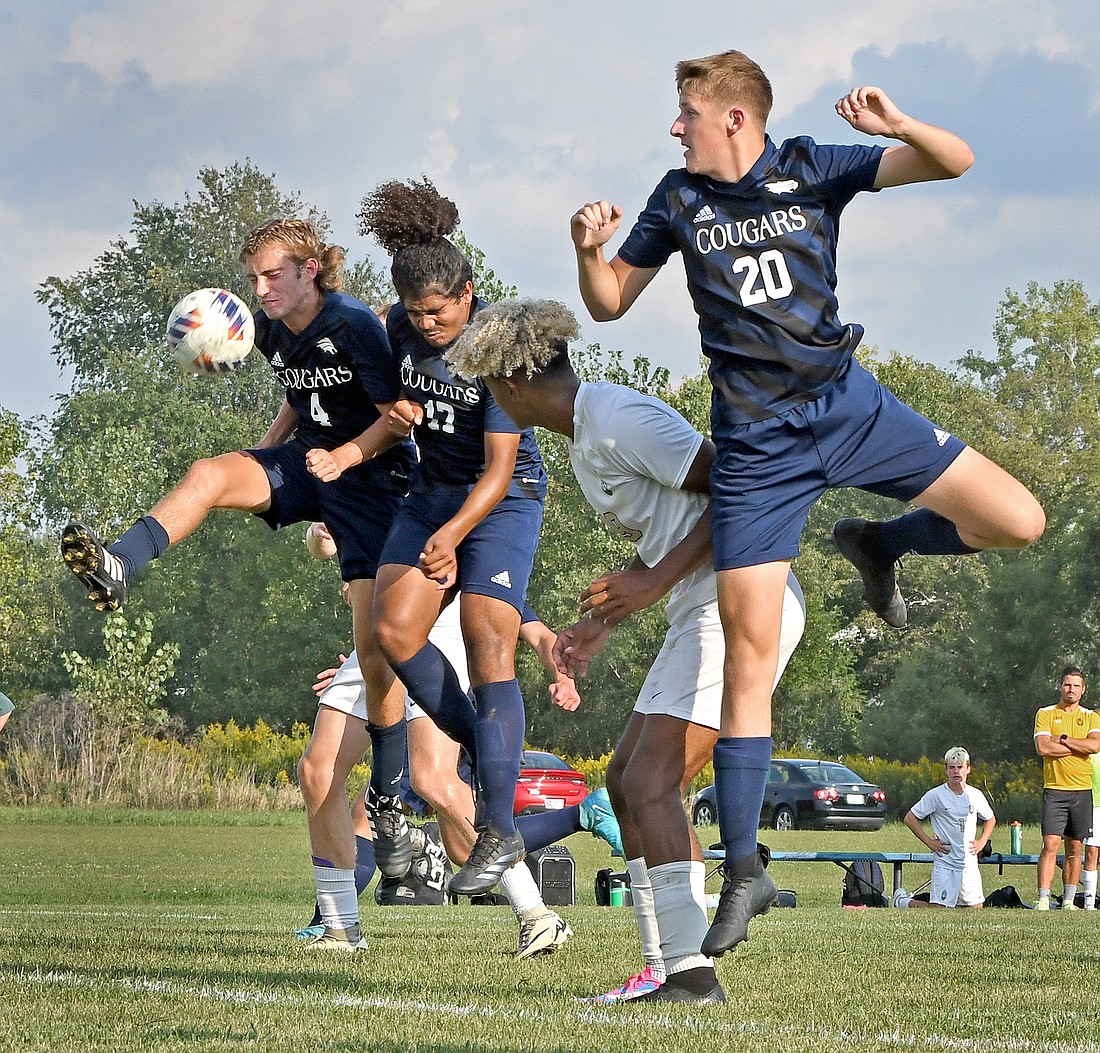 Battling for the ball in the first half are (L-R) Siimon Avey and Jayce Dixon of LCA, Trayvon Senders of Wawasee and Aaron Gause of LCA...Nieter