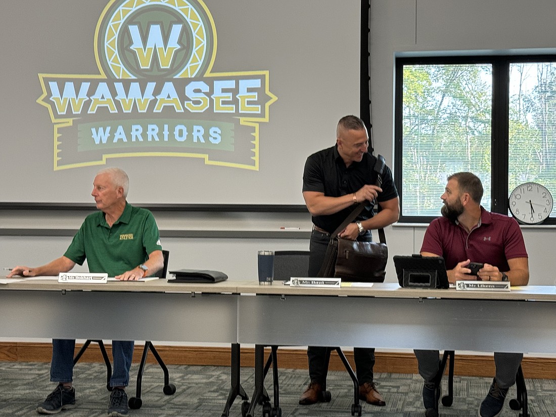 Steve Baut and Neil Likens talk before the regular September board meeting. The board approved numerous agenda items, including a GMP amendment for the Milford Elementary School project. Pictured (L to R) are board members Don Bokhart, Baut and Likens. Photo by Marissa Sweatland, InkFreeNews