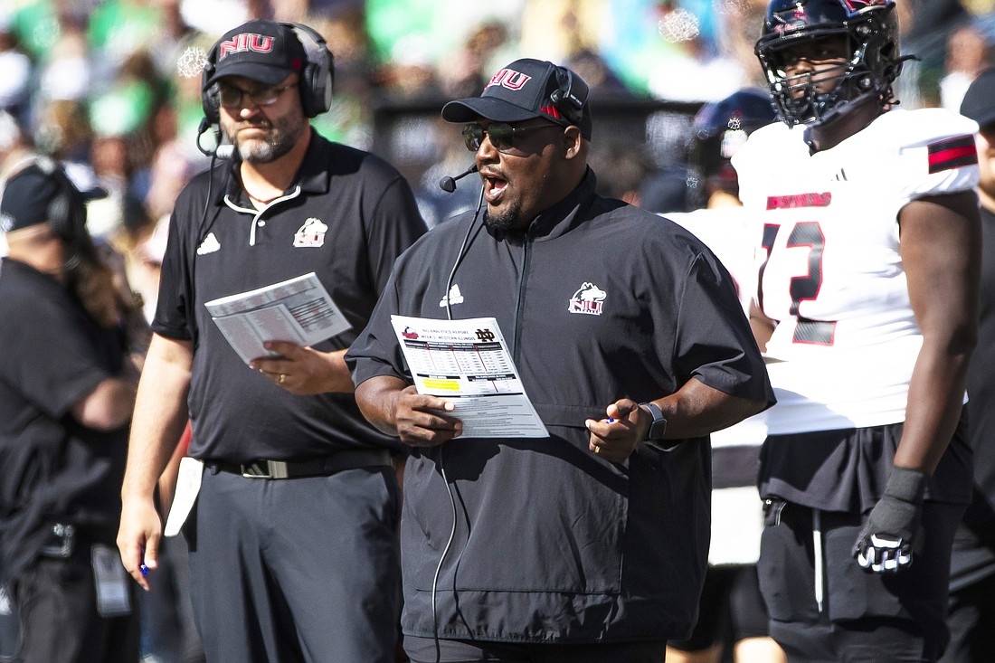 Northern Illinois head coach Thomas Hammock, center, talks into his headset during an NCAA college football game against Notre Dame, Saturday, Sept. 7, 2024, in South Bend, Ind. (AP Photo/Michael Caterina)