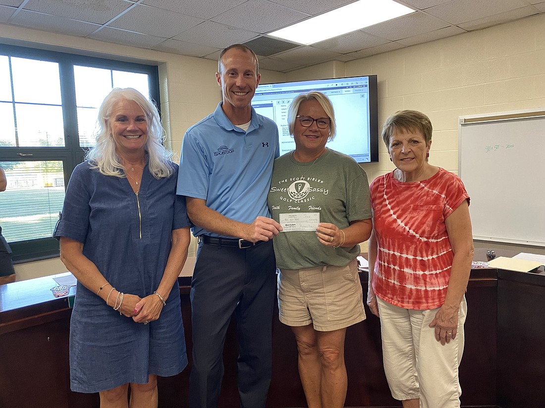 At the Tippecanoe Valley School Board meeting on Monday, the Tippecanoe Valley School Corp. received a $27,500 donation raised in part from the Scott “Bibs” Bibler Sweet Sassy Golf Classic. Part of the money, about $6,000, came from donations in memory of late Valley teacher and coach Mike Hoyt who passed away in August. Pictured (L to R) are Golf classic committee member Sara Boganwright, TVSC Board President Adam Heckaman, Bibler’s widow Stephanie Bibler and Hoyt’s widow Diana Hoyt. Photo by Leah Sander, InkFreeNews