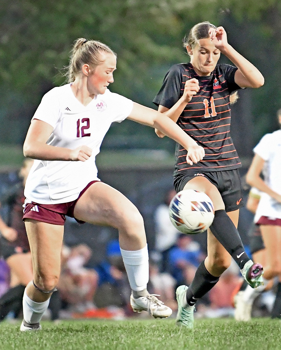 Sophomore Haidyn Elliott (R) of Warsaw controls the ball as CMA's Avery Loehr defends during Tuesday night's match...Nieter