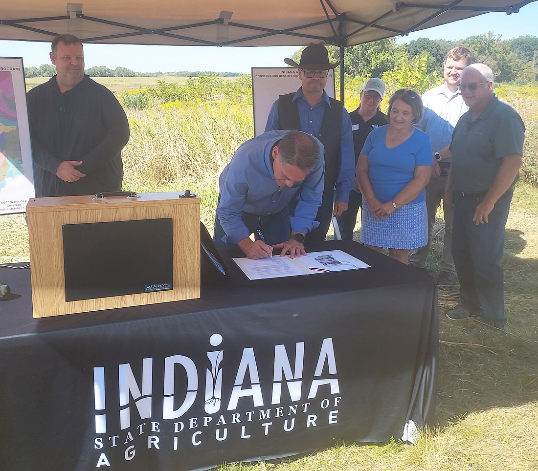 Don Lamb, director of the Indiana state Department of Agriculture, signs the Conservation Reserve Enhancement Program agreement at Zolman Farms Wednesday. Photo by Jackie Gorski, Times-Union