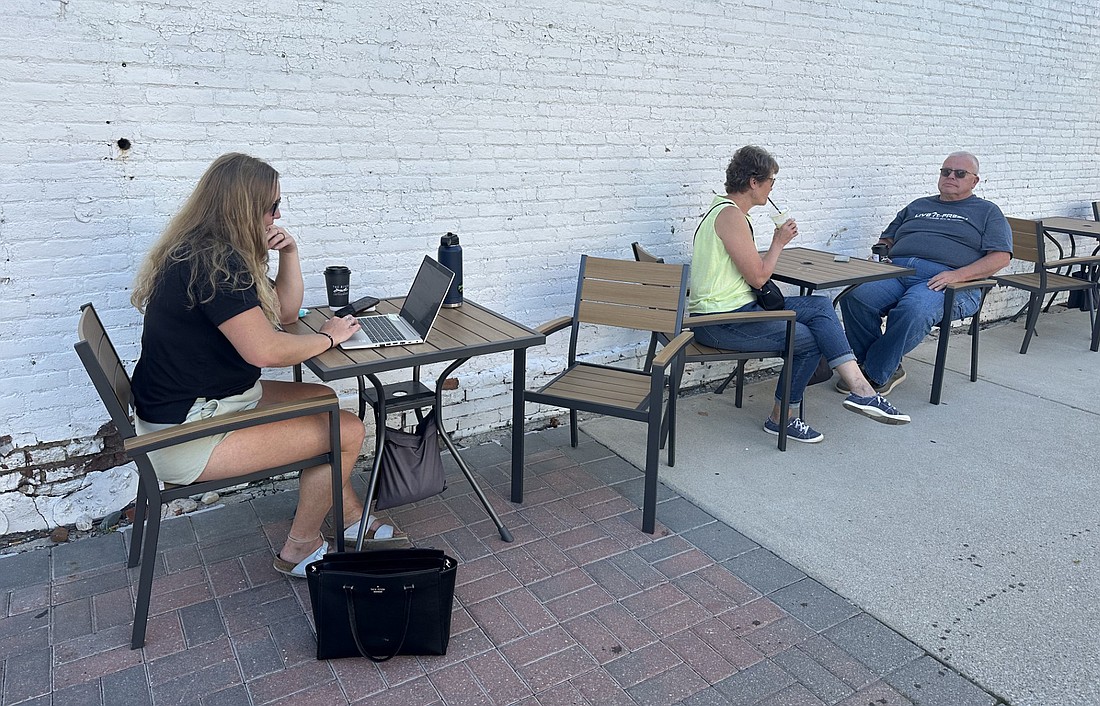 Taking advantage Friday of the outdoor seating at The River Coffeehouse Downtown are (L to R) Bria Hartmann and Pam and Scott Peters. The Warsaw Board of Public Works and Safety approved updating the outdoor furnishing rules Friday to extend the season and eliminate hours of operation. Photo by David Slone, Times-Union