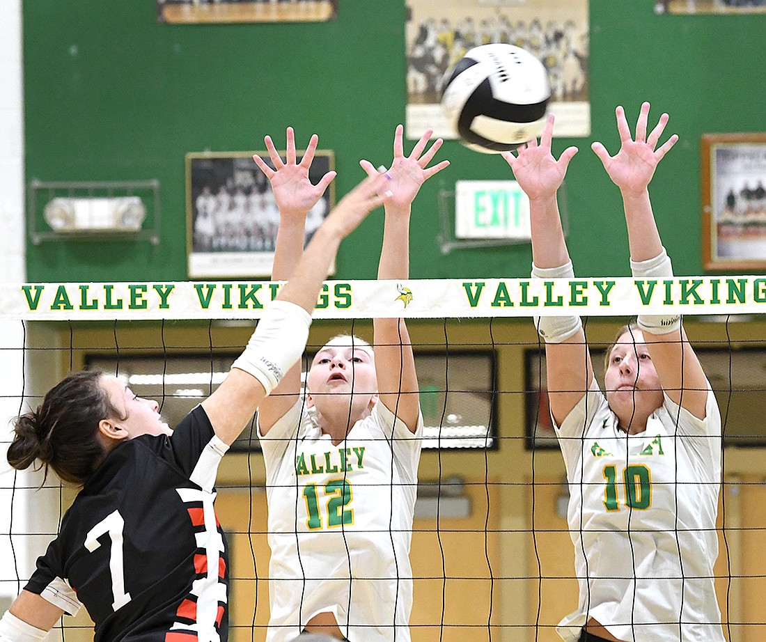 Kercklyn Miller of John Glenn tries for a kill as Valley's Autumn Parker and Mackaylie Costello go up for a block...Nieter