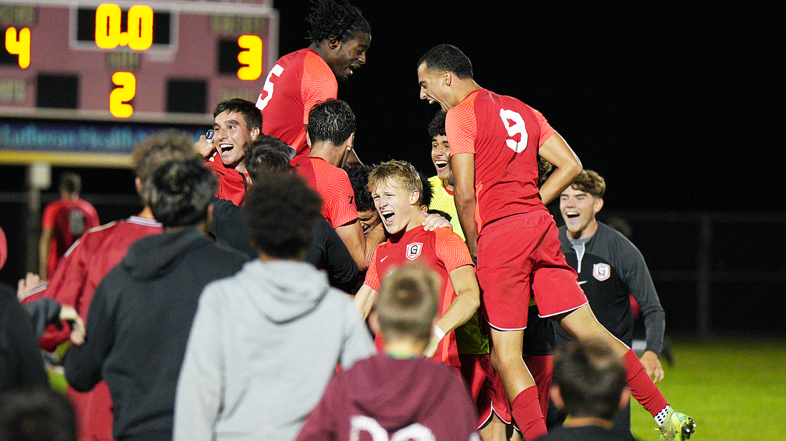 Grace’s Kyle Holwerda (center) is mobbed by his teammates after scoring the game-winning goal to upset No. 5 IWU Wednesday.