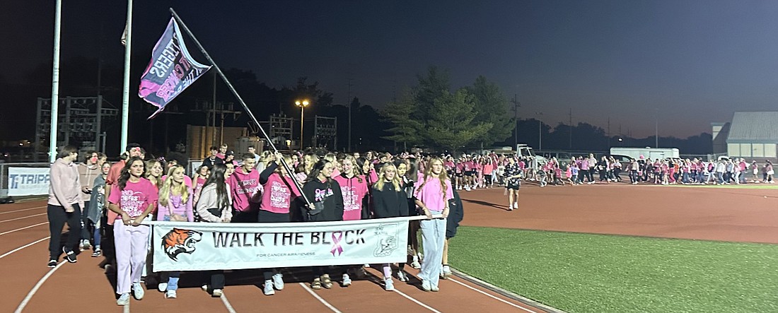 The Warsaw Community High School Cheer Block leads the “Walk the Block” around the track Friday night as part of Pink Out Night. Photo by David Slone, Times-Union