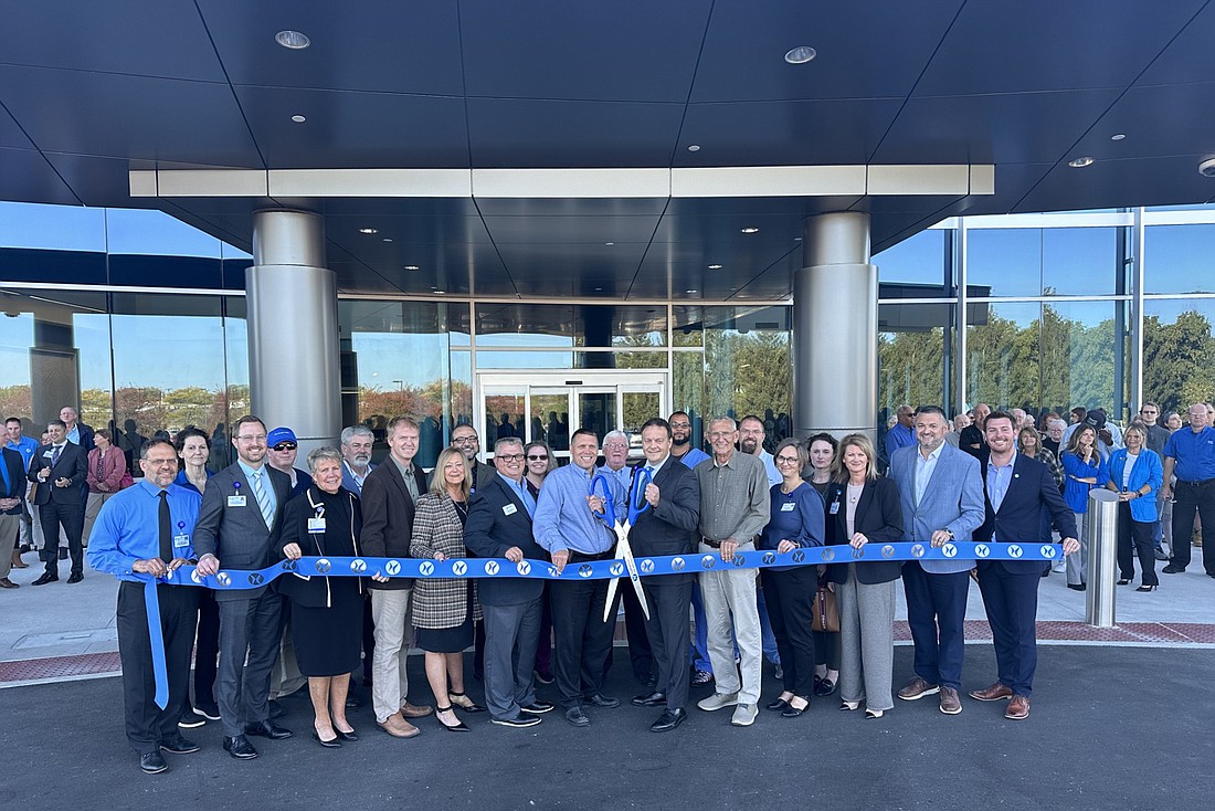 Lutheran Kosciusko Hospital CEO Chad Towner (center with scissors) cuts the ribbon during the ribbon-cutting ceremony Tuesday for the hospital’s renovations. Photo by David Slone, Times-Union