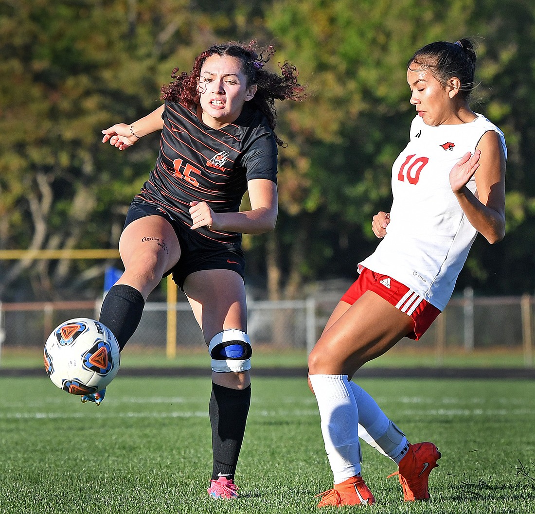 Warsaw senior Yessenia Benitez sends the ball upfield as Goshen's Nerelda Arriaga moves in to defend...Nieter