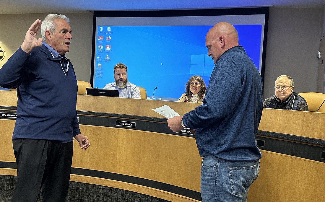 Warsaw Mayor Jeff Grose (R) gives Jeff Owens (L) the oath of office for the Warsaw Plan Commission, while looking on are (L to R, seated) City Planner Justin Taylor, Commission Co-Chair and Councilwoman Diane Quance and Commission member Jim Gast. Photo by David Slone, Times-Union