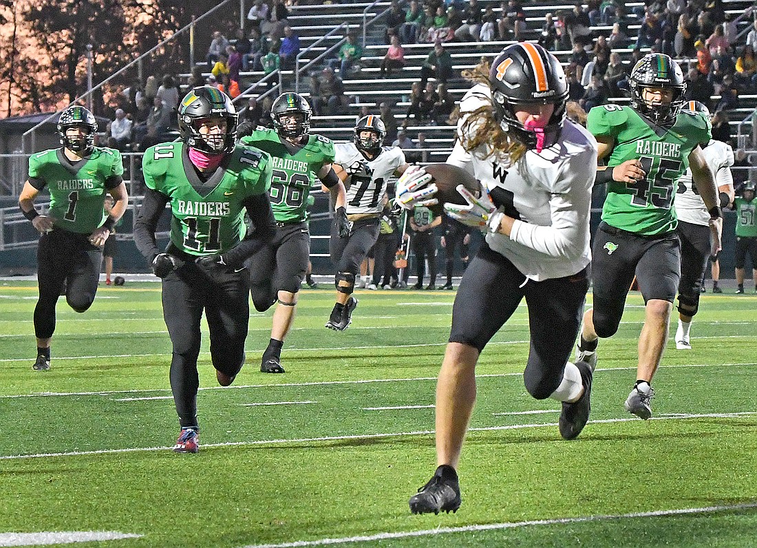 Aftere making a catch, senior Ethan Egolf of Warsaw tucks the ball away while leaving a trail of Northridge defenders en route to scoring Warsaw's first touchdown of the night...Nieter