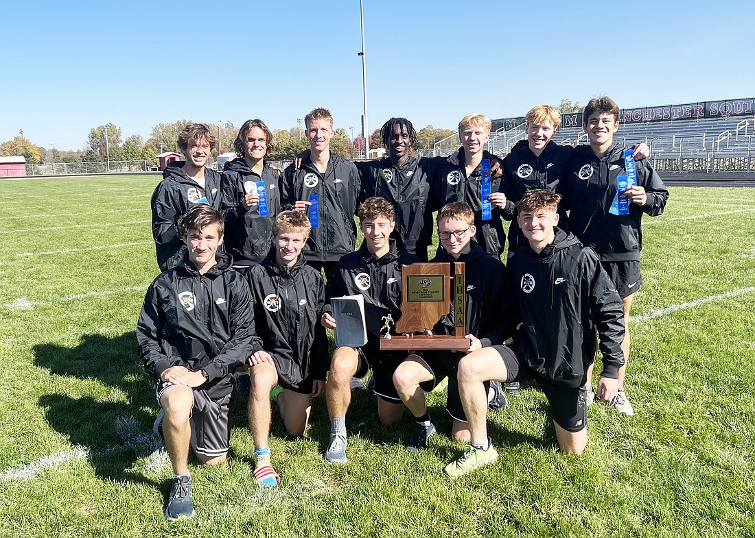 The Warsaw boys cross country team celebrates with its newest piece of hardware after winning its IHSAA sectional at Manchester Saturday.