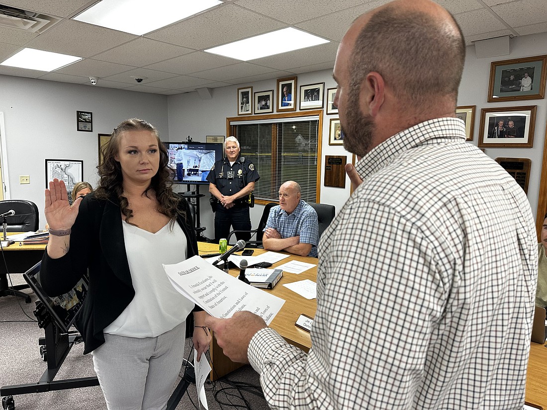 Winona Lake town attorney Adam Turner (R) gives the oath to Amanda Escalante, the town’s newest and first full-time female police officer. Photo by David Slone, Times-Union