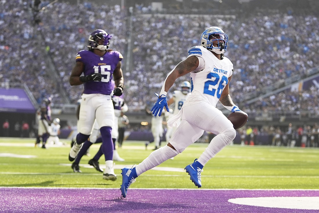 Detroit Lions running back Jahmyr Gibbs (26) runs for a 45-yard touchdown as Minnesota Vikings linebacker Dallas Turner (15) pursues during the first half of an NFL football game Sunday, Oct. 20, 2024, in Minneapolis. (AP Photo/Abbie Parr)