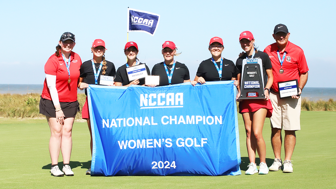 The Grace Women’s Golf team holds up a banner after winning the NCCAA National Championship Wednesday.