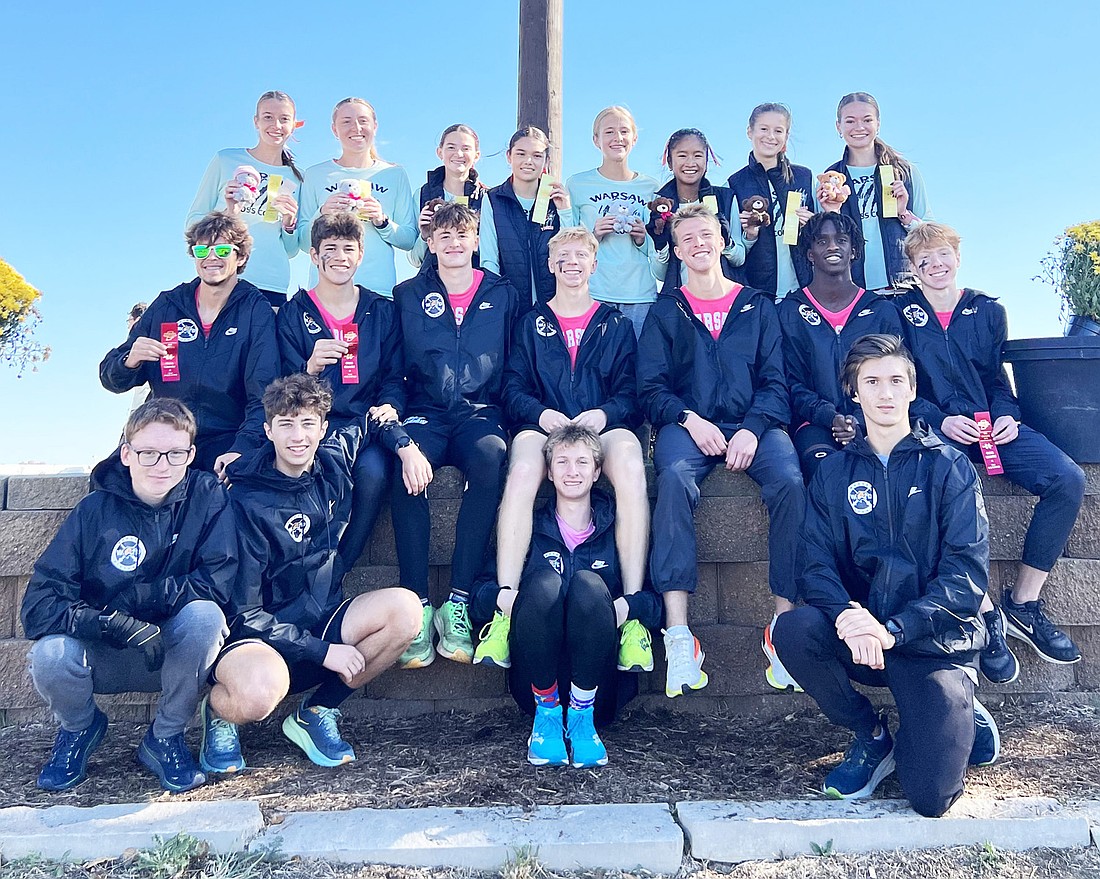 The Warsaw boys and girls cross country teams celebrate after both advancing to the state meet out of the New Haven Regional.