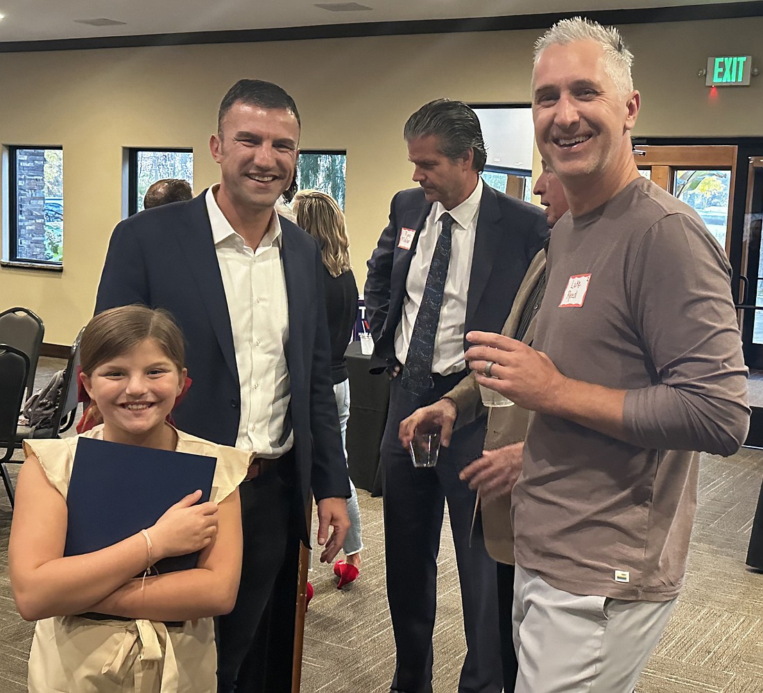 Second District U.S. Congressman Rudy Yakym (L), with his daughter Eliza, poses for a photo with Luke Reed (R) Tuesday at the Kosciusko County GOP Hall of Fame annual dinner. Indiana District 9 Sen. Ryan Mishler (C) and Warsaw Common Councilman Mike Klondaris (back, R) are standing behind them talking to Jean Northenor (standing behind Yakym). Photo by David Slone, Times-Union