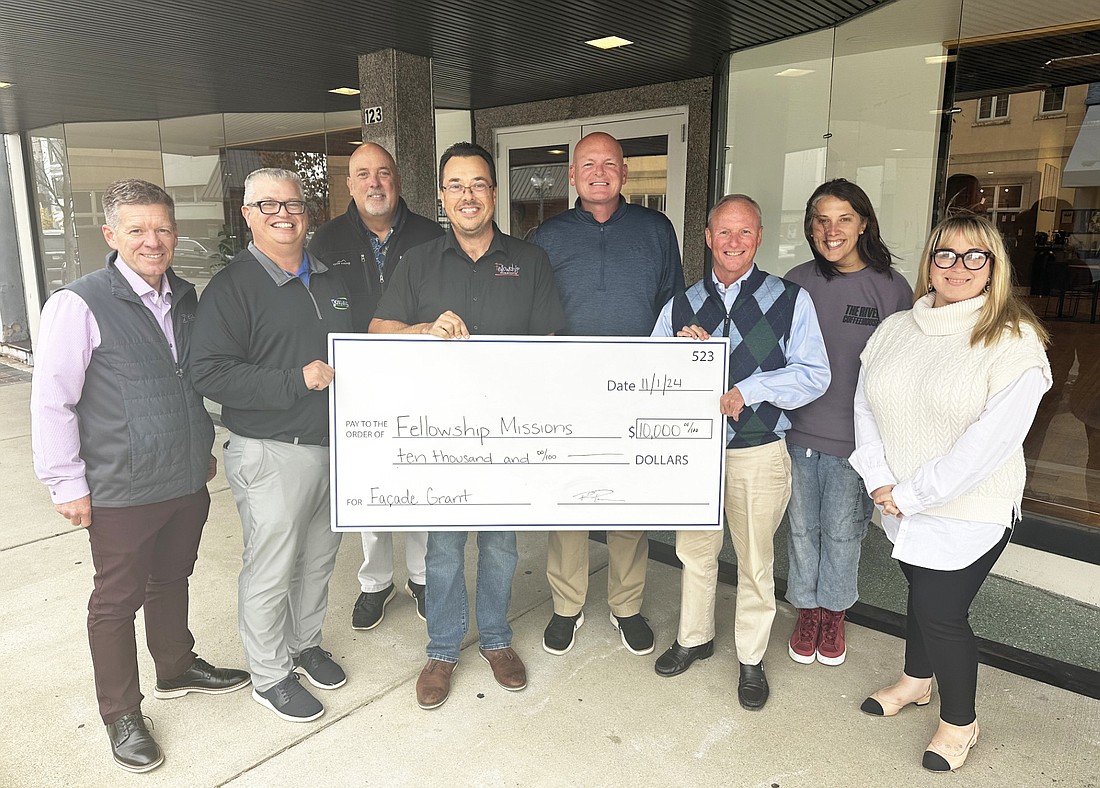 Main Street Warsaw presented a $10,000 facade grant to Fellowship Missions’ The Gathering Place Friday. Pictured (L to R) are Bob Vitoux, OrthoWorx; Rob Parker and Scott Wiley, Main Street Warsaw; Eric Lane, Fellowship Missions; Jeff Grose, Warsaw mayor; Terry Sweeney, Main Street Warsaw; Erica Deuel, Generous Coffee; and Nora Christiansen, Main Street Warsaw. Photo by David Slone, Times-Union