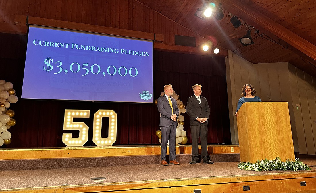 At Lakeland Christian Academy’s 50th year celebration Friday at Rodeheaver Auditorium in Winona Lake, (L to R) LCA Superintendent Joe Elrod, Board President Nate Bosch and Board Vice President Lindsay Gergely announce LCA’s building campaign aimed to bring all LCA students onto one campus in Winona Lake. Current fundraising pledges total $3,050,000. Photo by David Slone, Times-Union