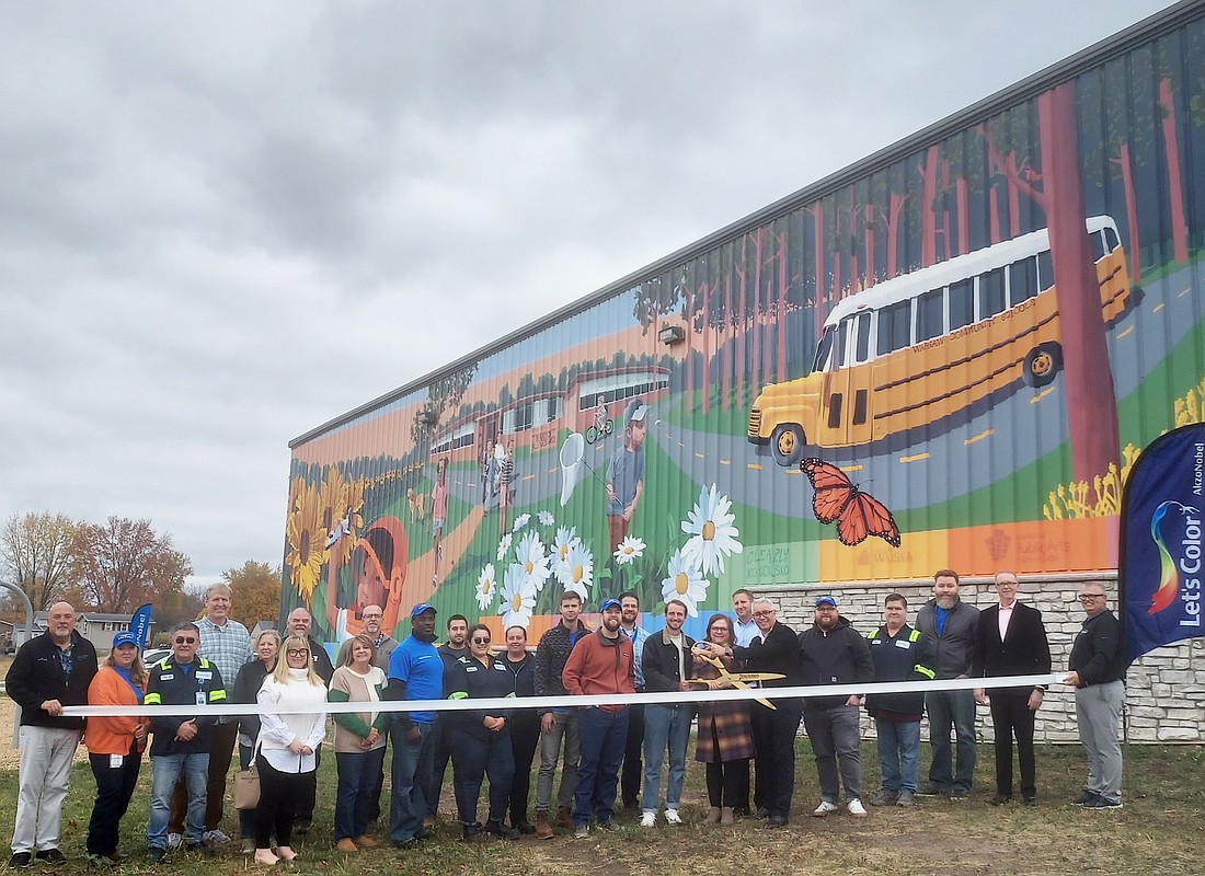 The completion of a mural at the Downtown Warsaw YMCA was celebrated with a ribbon-cutting Friday. Pictured are muralist Chris Catalogna and members of AkzoNobel, the Kosciusko Chamber of Commerce, Main Street Warsaw, Warsaw Public Arts Commission and Clearly Kosciusko.  Photo by Jackie Gorski, Times-Union