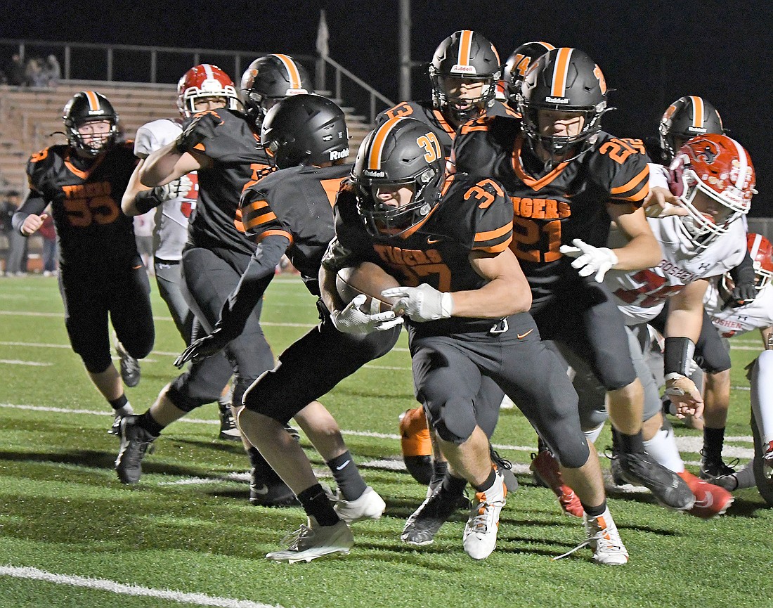 Warsaw junior Daylon Fitzpatrick is followed into the end zone by a host of other Tigers during the third quarter...Nieter