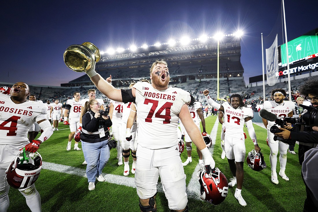 Indiana offensive lineman Bray Lynch (74) and teammates celebrate with the Old Brass Spitoon after defeating Michigan in an NCAA college football game, Saturday, Nov. 2, 2024, in East Lansing, Mich. (AP Photo/Al Goldis)