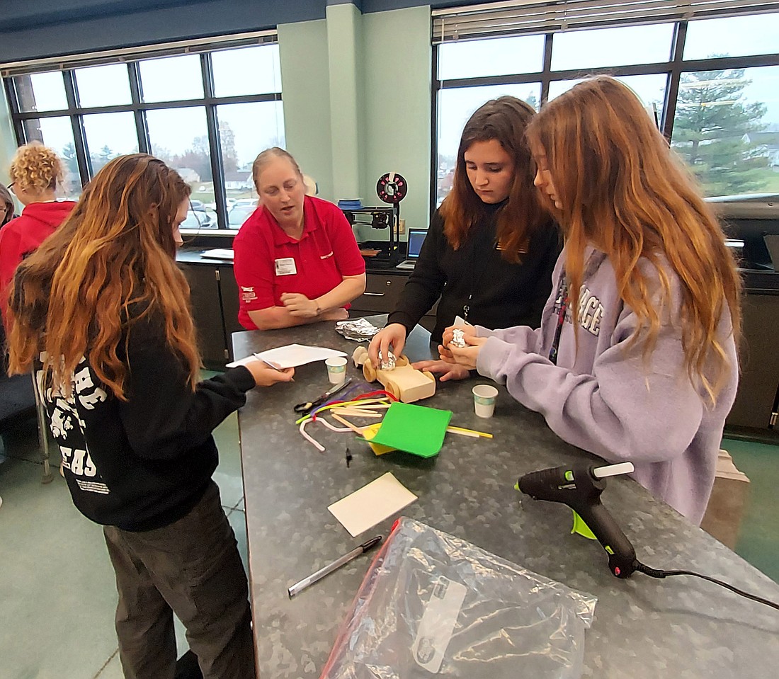 Abigail Parsons (in red shirt) helps Edgewood Middle School students during “Forget princess, I want to be an engineer” Thursday. Photo by Jackie Gorski, Times-Union