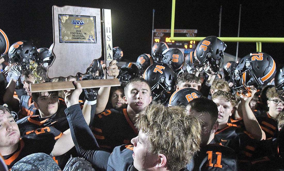 The Tigers proudly hold up Warsaw's first-ever football regional trophy...NIeter