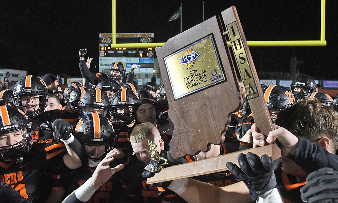 The semi-state trophy is proudly held high after the Warsaw victory over Merrillville...Nieter