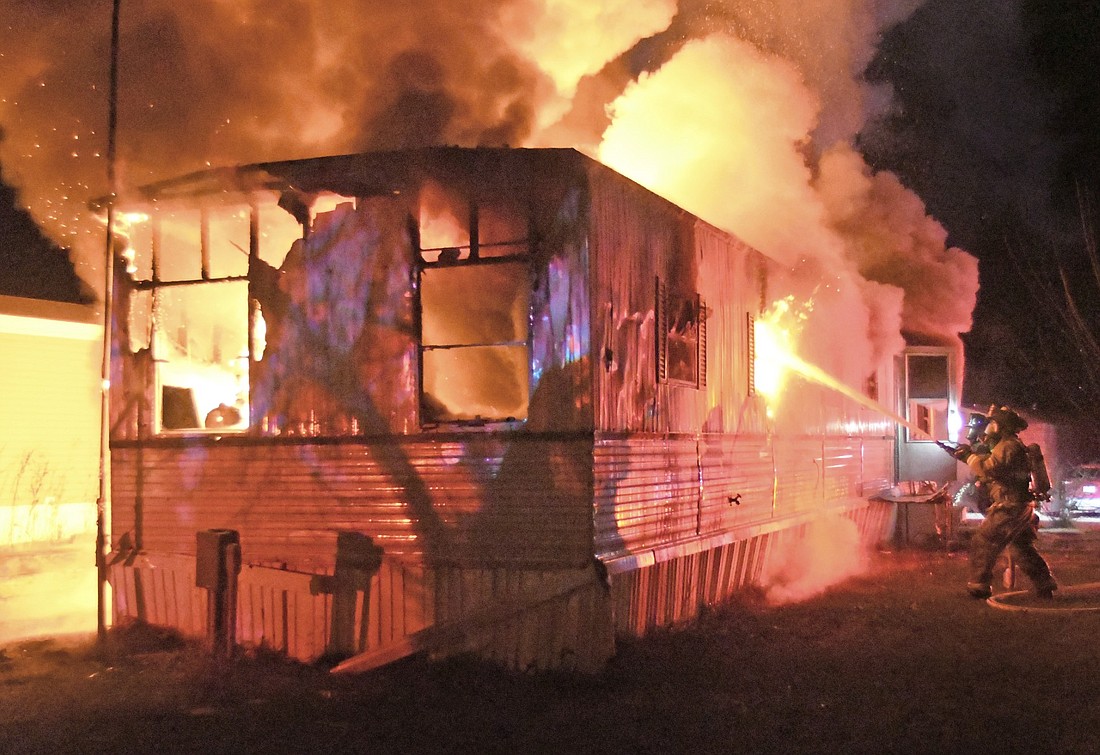 Water is doused on the fire as the blaze engulfs the mobile home. Photo by Gary Nieter, Times-Union