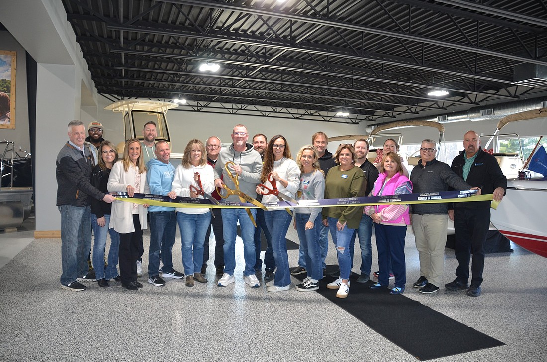 Pro Wake Water Sports in Leesburg celebrated its showroom expansion with a ribbon cutting Friday. Pictured (L to R) are, front row: Jeff Dyson, Syracuse-Wawasee Chamber of Commerce; Jeanetta Slabaugh, Syracuse-Wawasee Chamber of Commerce, Horizon Bank; Ashley Dillon, director, Syracuse-Wawasee Chamber of Commerce; Jeff Kiess, Pro Wake Watersports; Patty Richards; owner Mark Richards; Jenna Habegger, Pro Wake Watersports; Emily Shipley, president, North Webster-Tippecanoe Chamber of Commerce; Karen White, North Webster-Tippecanoe Chamber of Commerce Chamber; Dawn Jaggers, Kosciusko Chamber of Commerce; Rob Parker, president and CEO, Kosciusko Chamber of Commerce; Scott Wiley, member relations manager, Kosciusko Chamber of Commerce; back row: Shawn Brown, ambassador, Kosciusko Chamber of Commerce; Chris Scheeren, Syracuse-Wawasee Chamber of Commerce, Blue Barn Berry Farm; Russ Vance, ambassador, Kosciusko Chamber of Commerce, ReMax Results; Jason Dewart, Interra Credit Union, Syracuse-Wawasee Chamber of Commerce; Chris Trowbridge, North Webster-Tippecanoe Chamber of Commerce; Josh Himelick, North Webster-Tippecanoe Chamber of Commerce; Northwest Bank; and Nicole Nabinger, Kinetic Firearms, North Webster-Tippecanoe Chamber of Commerce. Photo by Phoebe Muthart, InkFreeNews