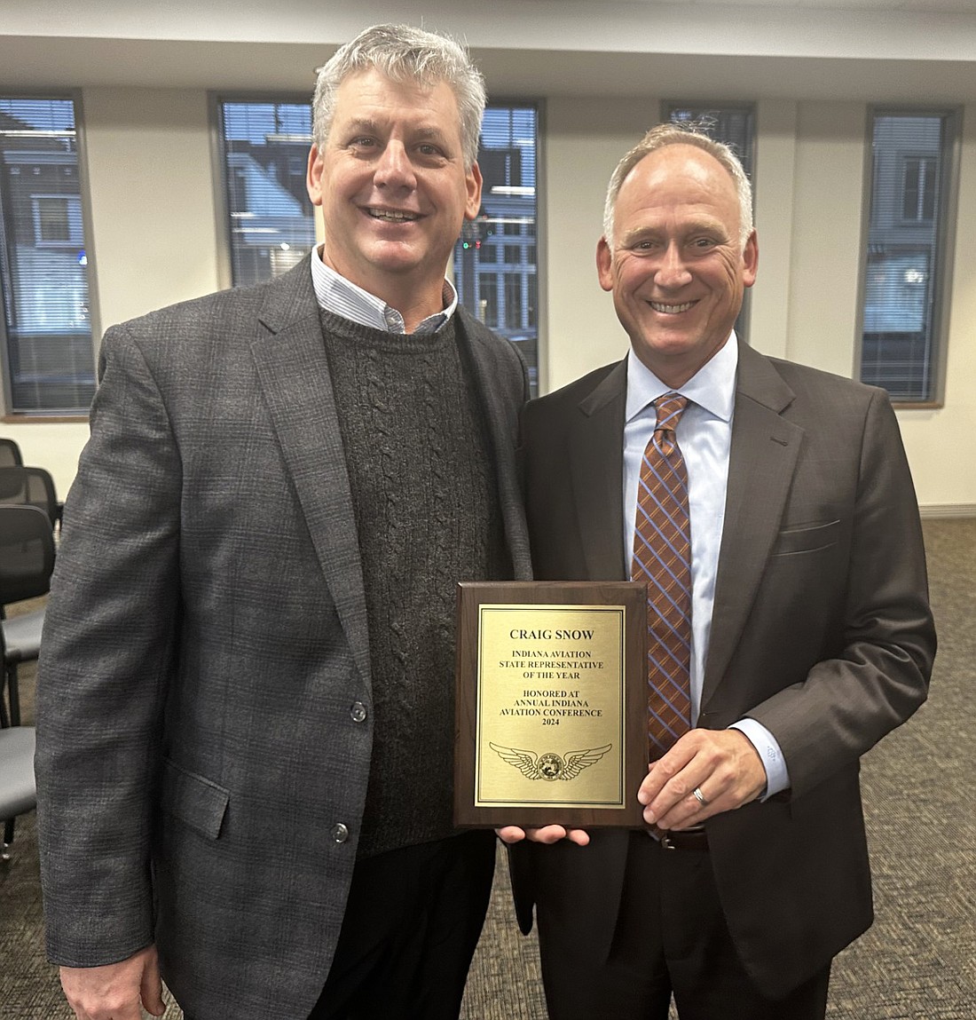 Bart Giesler (L), executive director for Aviation Indiana, presents District 22 state Rep. Craig Snow (R) with the Indiana Aviation State Representative of the Year Award at Tuesday’s Warsaw Board of Aviation Commissioners. Photo by David Slone, Times-Union