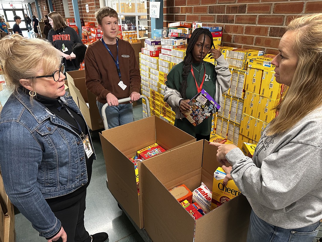 Edgewood Middle School Principal JoElla Hauselman (L) listens to teacher and food drive coordinator Tammy Adamiec Tuesday about a need for more paper bags. Photo by David Slone, Times-Union