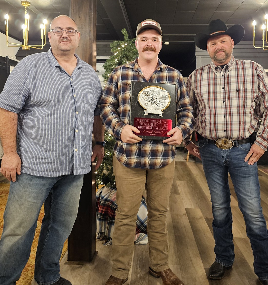 Jared Smith (C) was selected the Firefighter of the Year at the Pierceton Volunteer Fire Department’s annual Christmas dinner and awards ceremony. Also pictured are Chief Nathan Rhoades (R) and Assistant Chief Matt Brubaker (L). Photo Provided