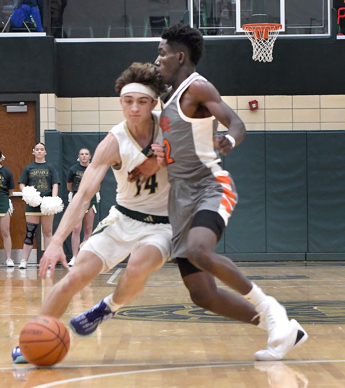 Junior Mydin Burgher of Warsaw uses his body while defending against Wawasee's Nolan Holzwart during the first quarter...Nieter