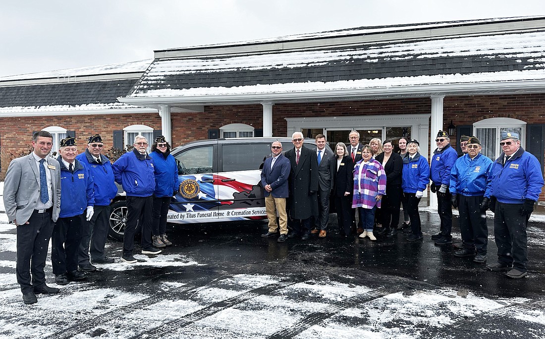 American Legion Post 49 Honor Guard, Titus Funeral Home & Cremation sole owner Cory Benz (eighth from left) and the Titus staff pose for a group photo in front of the Dodge Grand Caravan that Titus Funeral Home donated to Post 49 Thursday. The donation was presented at Titus Funeral Home & Cremation, 2000 E. Sheridan St., Warsaw. Photo by David Slone, Times-Union