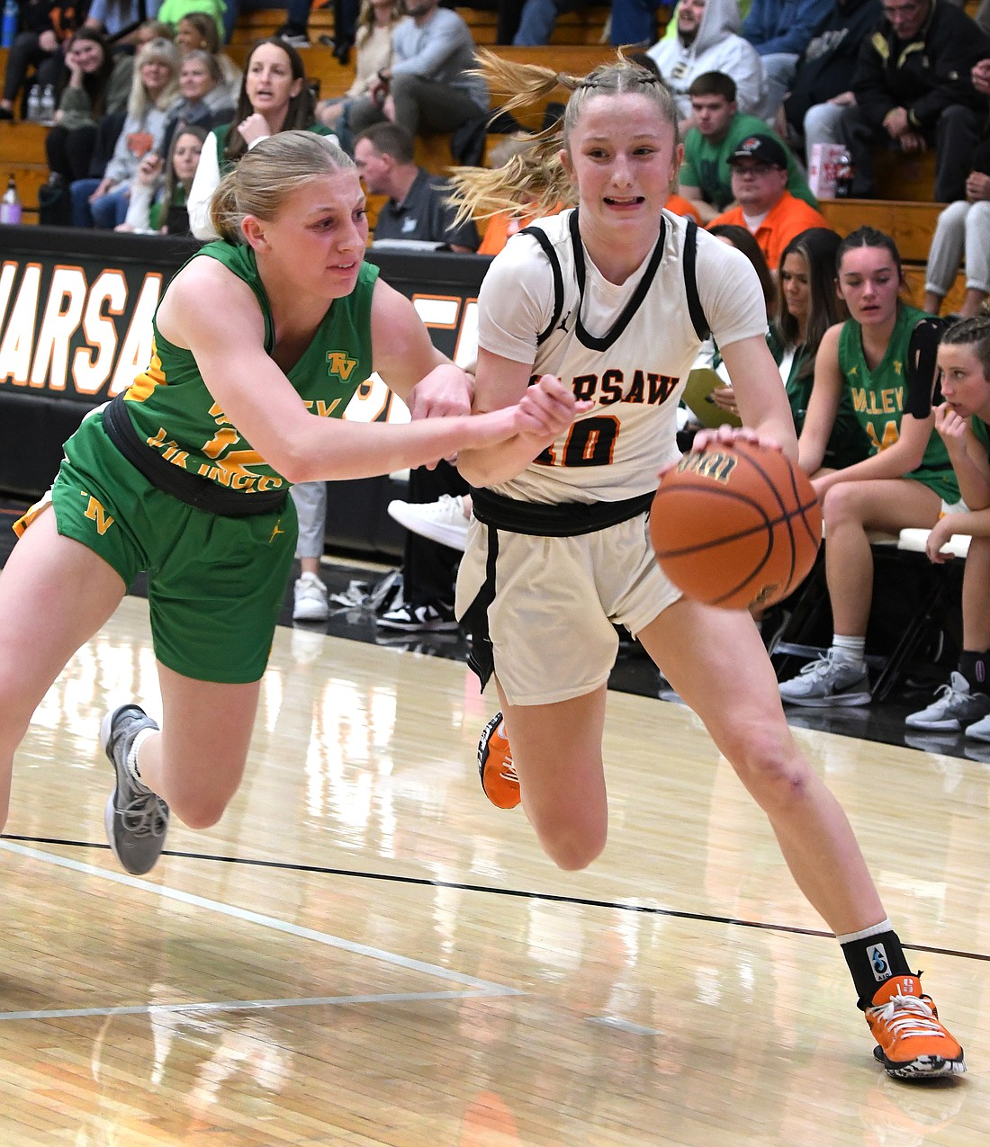 Warsaw junior Joslyn Bricker finds it rough going to the basket as Hadley Wise of Tippecanoe Valley defends...Nieter