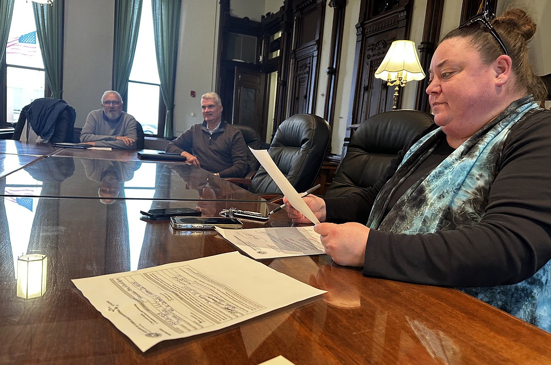 Excise officer April Tackett (R) looks over information for a new alcohol license application at Thursday’s Kosciusko County Alcohol Tobacco Commission meeting while commission members (L to R) Dan Woods and Mike Hall look on. Photo by David Slone, Times-Union