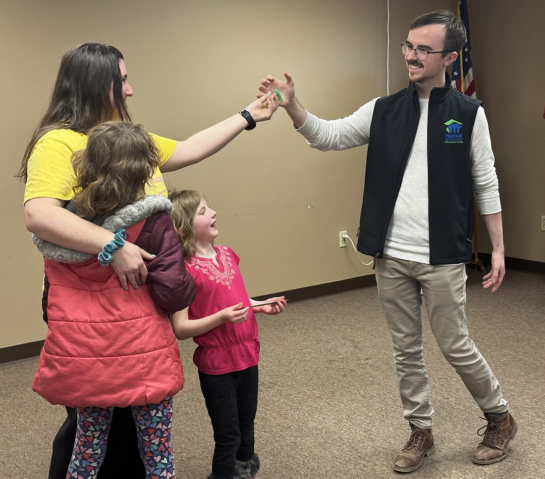 Habitat for Humanity of Kosciusko County Executive Director Ben Logan (R) gives the house keys to new homeowner Kimber Boyd and two of her four girls during the dedication ceremony Friday evening in Mentone. Photo by David Slone, Times-Union