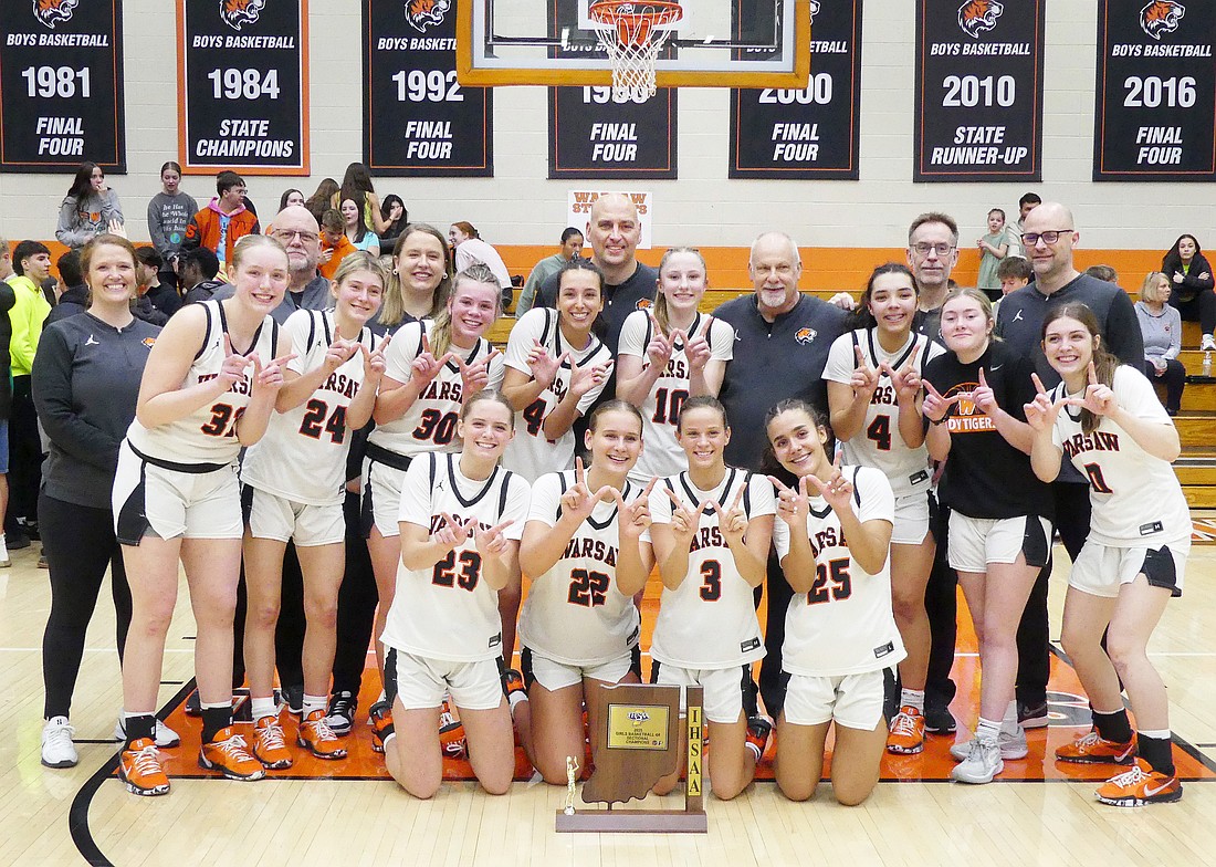 The Warsaw girls basketball team celebrates after capturing a sectional title on their home court Saturday night.