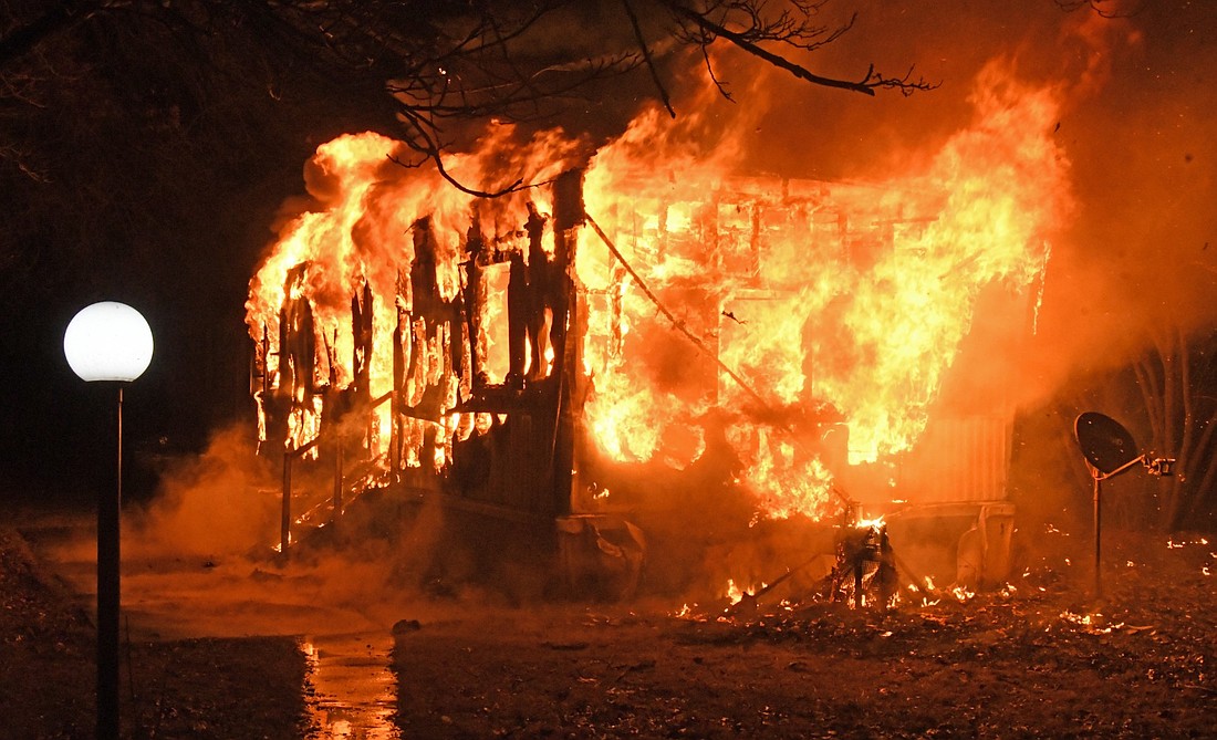 A mobile home is fully engulfed with flames Sunday night at Suburban Acres. Photo by Gary Nieter, Times-Union.