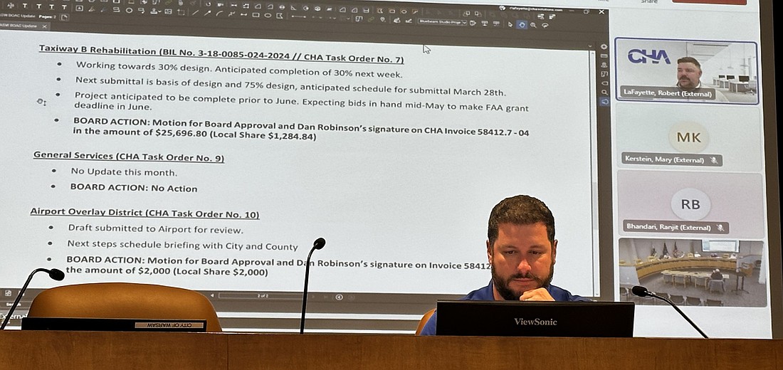 Warsaw Airport Manager Nick King listens to a report from Robert LaFayette (on screen) from CHA during the Warsaw Board of Aviation Commissioners meeting Tuesday. Photo by David Slone, Times-Union