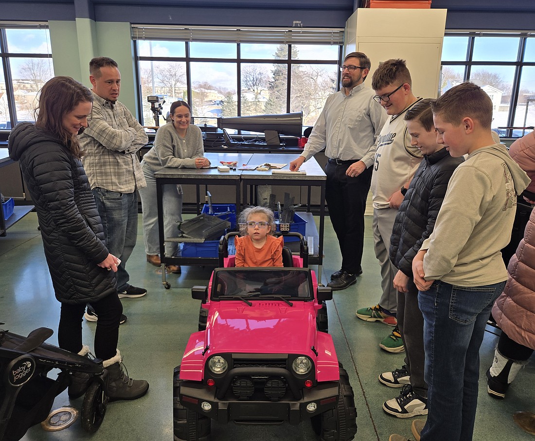 One of the GoBabyGo! teams talks with parent Steven Corbitt about how to modify daughter Lyla’s Jeep Thursday. Photo by Jackie Gorski, Times-Union