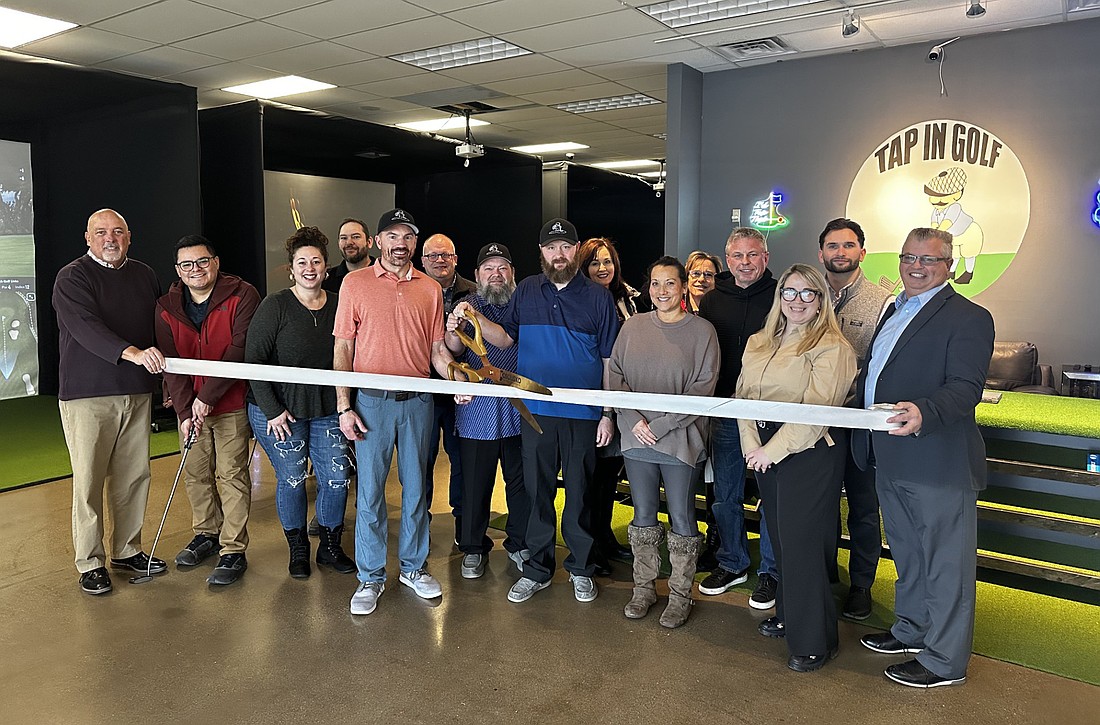 Tap In Golf partners Nathan Cline (left with scissors) and Steven Myers (right with scissors) cut the ribbon during a ribbon-cutting ceremony Thursday with the Kosciusko Chamber of Commerce. Also pictured are Chamber staff and ambassadors. Photo by David Slone, Times-Union