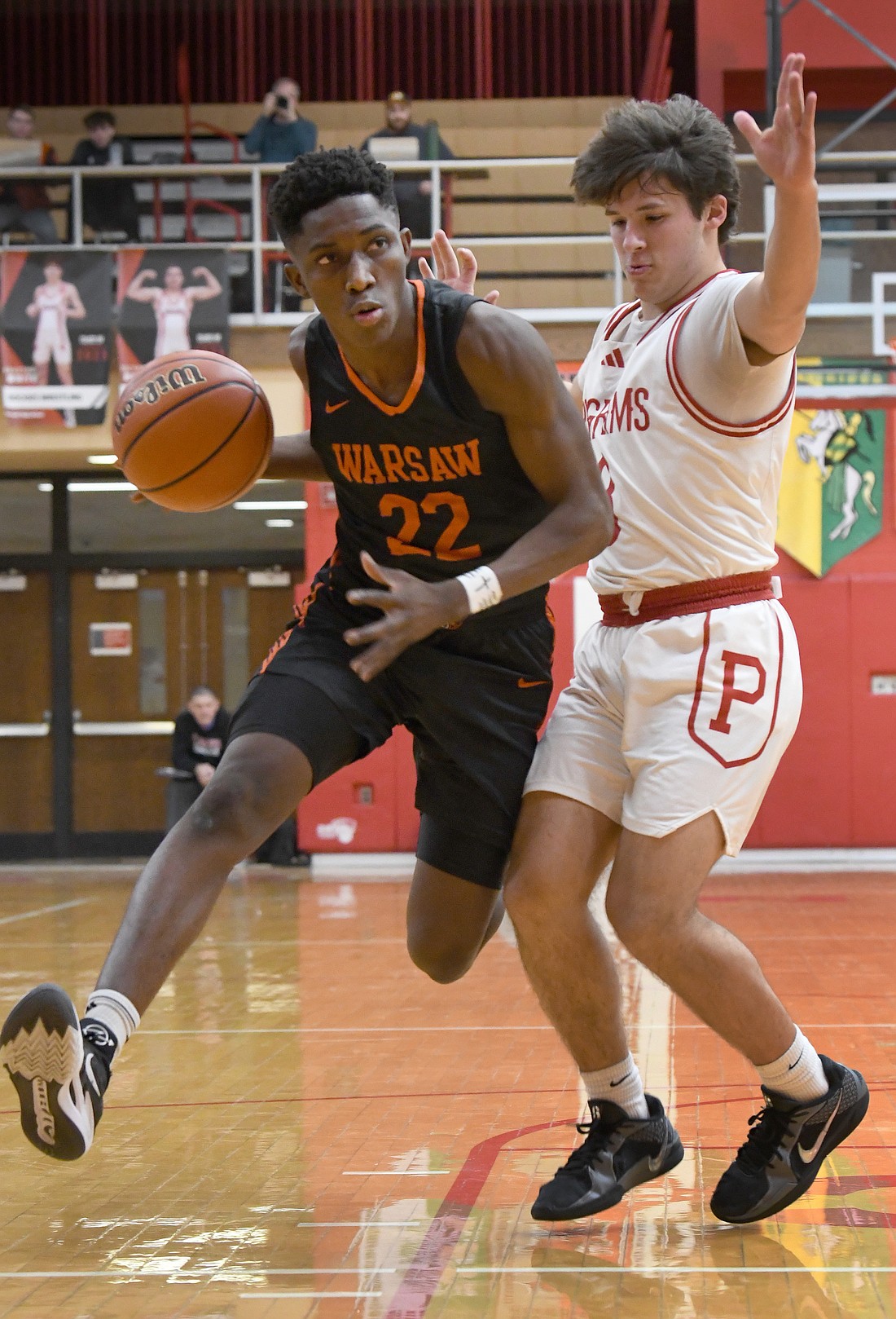 Putting a lot of air under his feet, junior Mydin Burgher of Warsaw heads to the basket during Friday night's game at Plymouth...Nieter