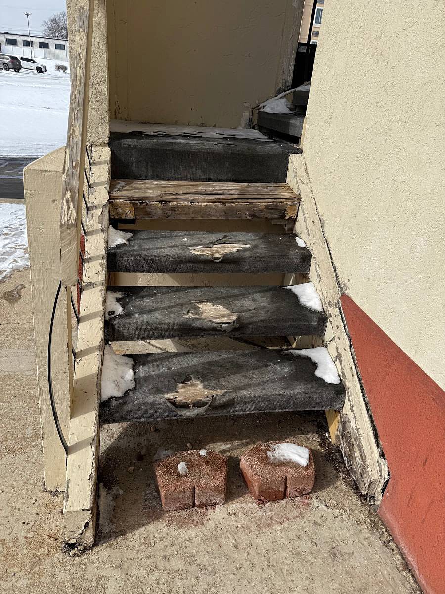 The bottom exterior stair of the Deluxe Inn is missing and replaced with two bricks. Other stairs appear to be possibly damaged. Photo by Madison Hart, InkFreeNews