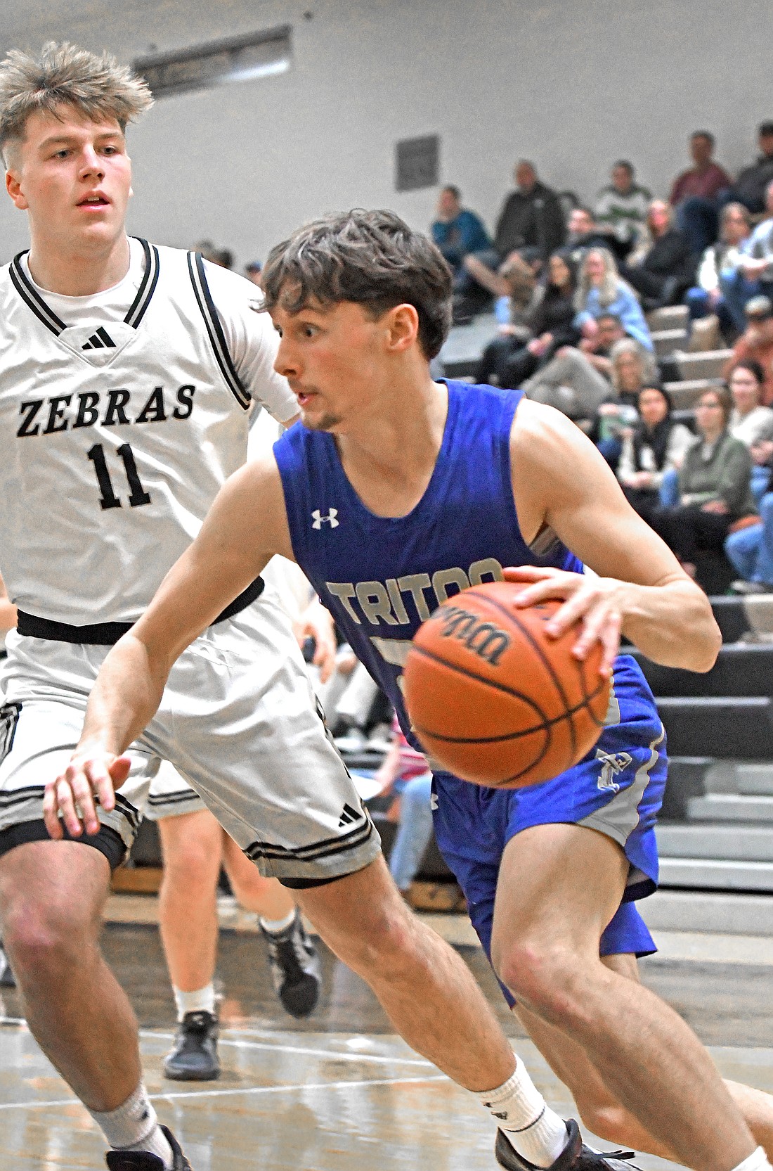 Junior Gage Riffle of Triton drives to the basket during Tuesday night's game at Rochester as Tanner Reeinartz defends...Nieter